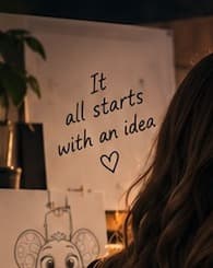 Viktoria R. reviewing a hand-drawn concept sketch of Cheese Mouse pinned to the studio wall